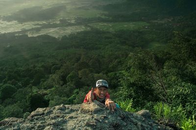 Portrait of young man gesturing for help on mountain