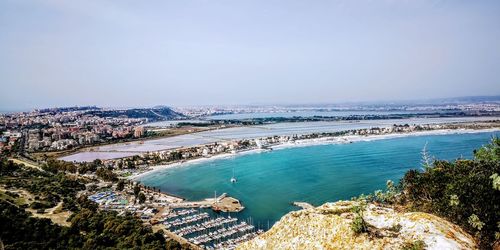 High angle view of sea and cityscape against sky