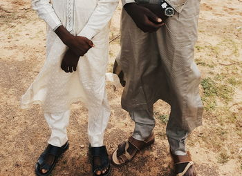 Low section of friends wearing traditional clothing on field