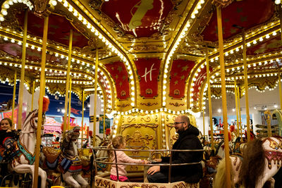 People in amusement park at night