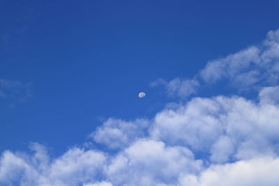 Low angle view of moon in blue sky