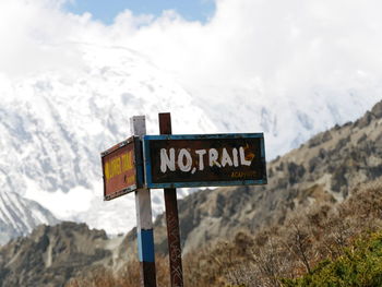 Information sign on mountain against sky. no trail sign. road ends. 