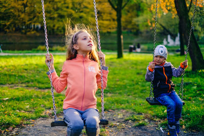 Siblings on swing at park