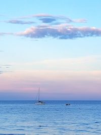 Sailboat sailing on sea against sky during sunset