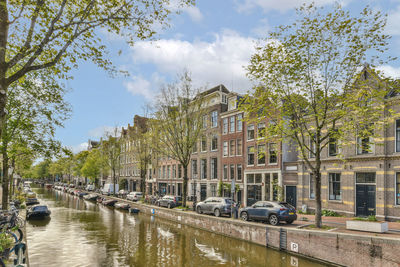 Buildings by lake against sky