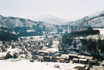 High angle view of townscape and snowcapped mountains against sky