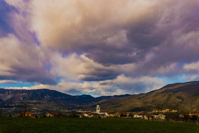 Scenic view of landscape and mountains against cloudy sky