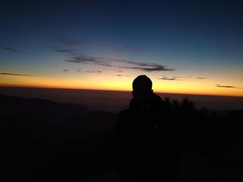 Silhouette man standing against sky during sunset