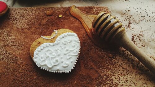 High angle view of cookie and honey dipper on table