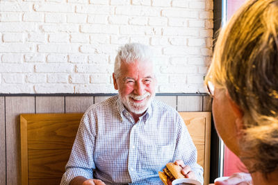 Smiling man with woman eating food in restaurant