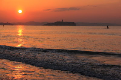 Scenic view of sea against orange sky