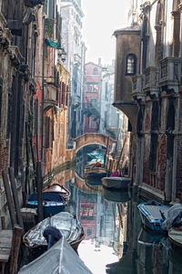 Boats in canal amidst buildings