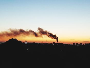 Smoke emitting from chimney against sky at sunset