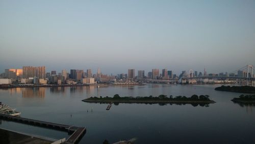 Scenic view of river by buildings against sky