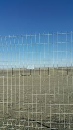Fence on field against clear sky