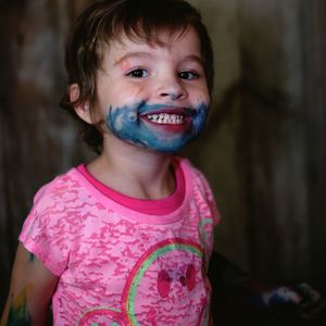 Portrait of mischievous girl with painted face