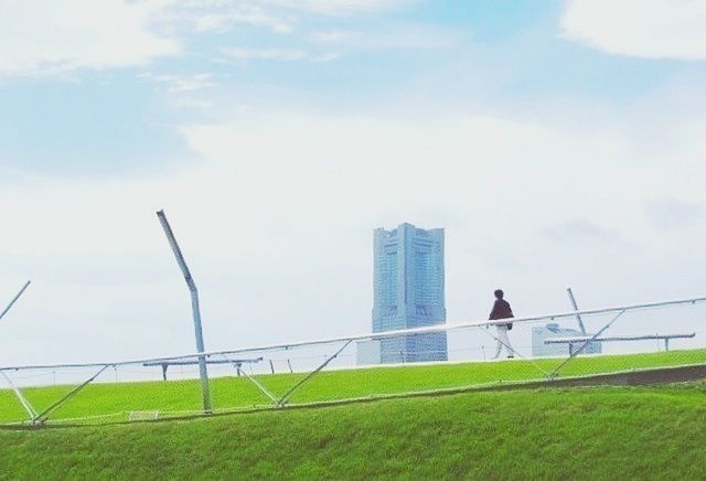 building exterior, built structure, sky, architecture, grass, men, full length, lifestyles, leisure activity, rear view, field, one animal, day, standing, animal themes, green color, railing, outdoors