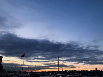 Low angle view of street lights against dramatic sky