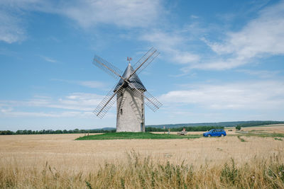 Traditional windmill on field against sky