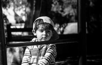 Cute boy looking away in park during sunny day