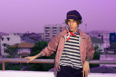 Young man standing against buildings in city