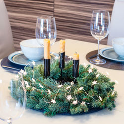 Christmas festive table decoration with spruce wreath and stars garland. 