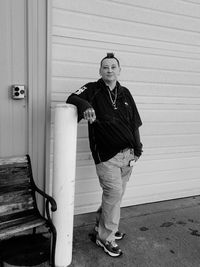 Full length of woman standing against shutter