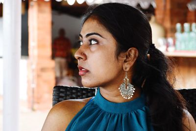 Beautiful young woman looking away while sitting on seat