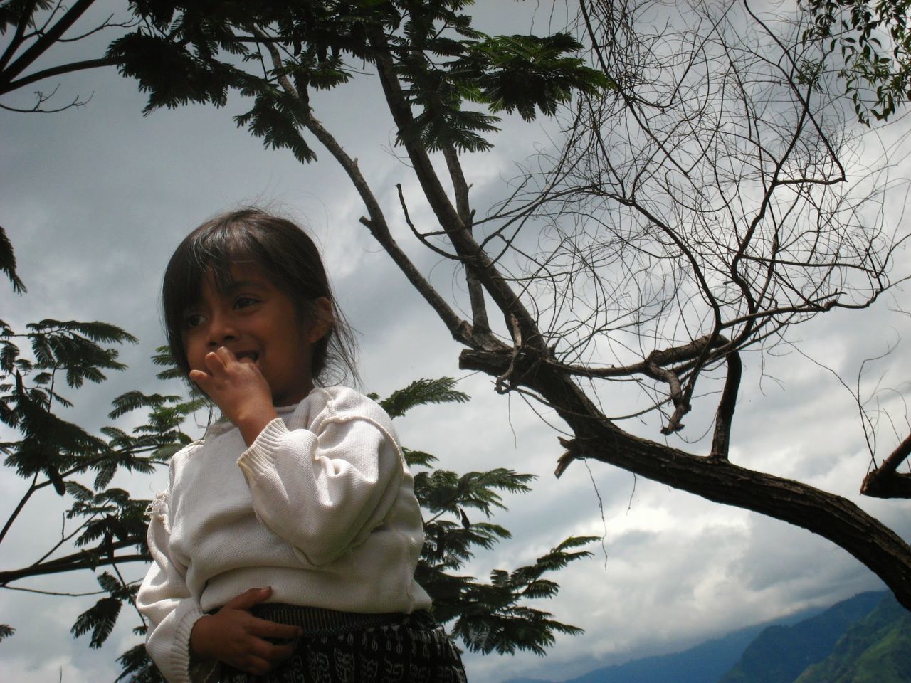 PORTRAIT OF YOUNG WOMAN STANDING ON TREE