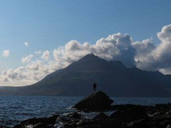 Scenic view of sea and mountains against sky