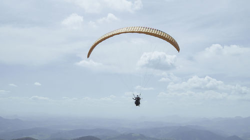 Person paragliding against sky