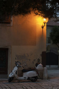 Motor scooter on street against buildings at night