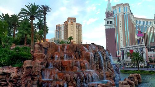 Panoramic view of buildings and palm trees against sky