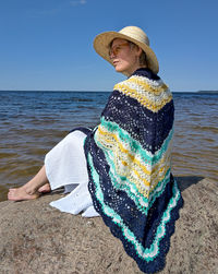 Woman wearing hat while sitting on beach