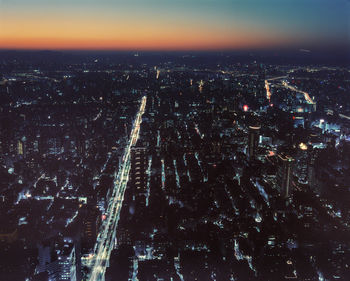 High angle view of illuminated city against sky at night