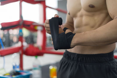 Midsection of man exercising in gym