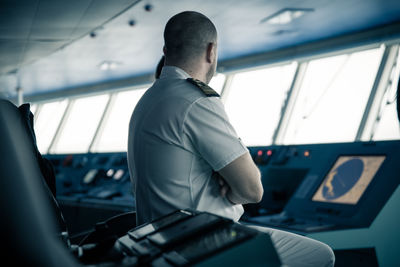 Rear view of man sitting in airplane