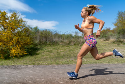 Full length of woman running on plant against sky