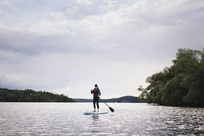 Woman paddle boarding on lake