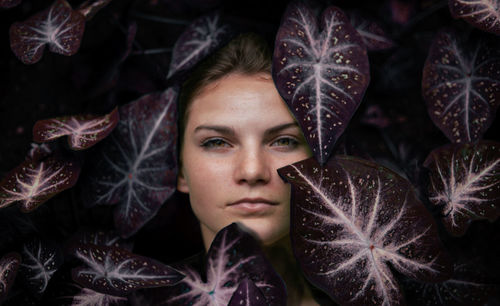 Portrait of young woman amidst leaves