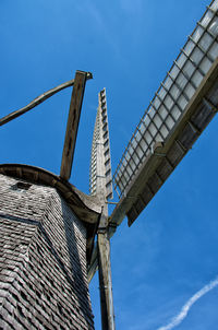 Low angle view of wind turbine against blue sky