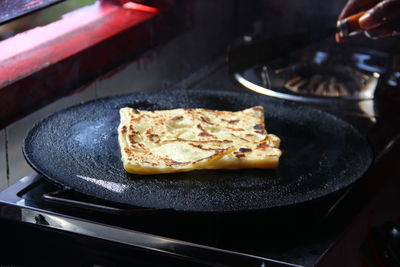 Close-up of food cooking on frying pan in kitchen