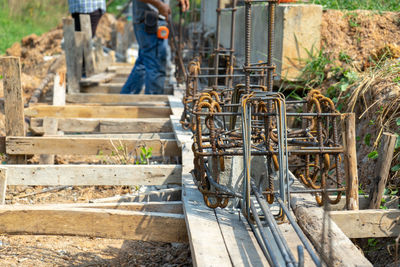 Low section of men working at construction site with structure of reinforcement steel