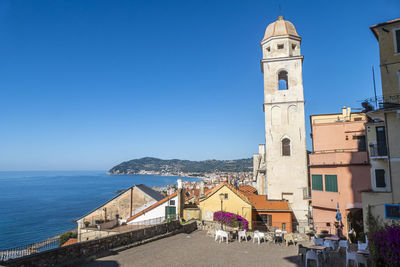 Panoramic view of sea and buildings against clear blue sky