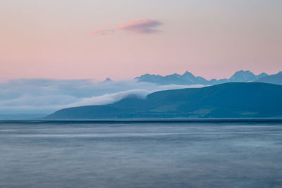 Scenic view of sea and mountains against sky during sunset