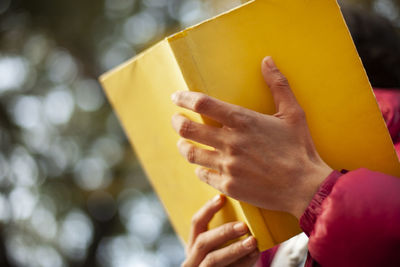 Midsection of woman holding yellow text