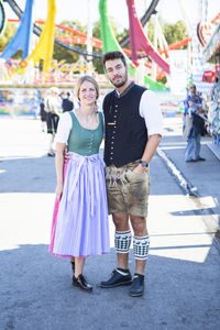 Portrait of couple standing at amusement park