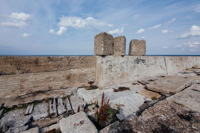 Abandoned military base by sea against sky