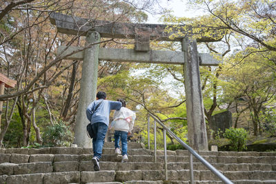 Rear view of man walking on steps