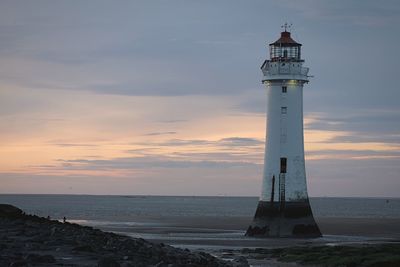 Lighthouse at seaside during sunset